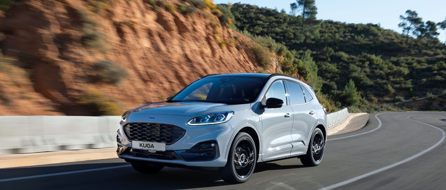 Ford Kuga Graphite Tech Edition. Dreiviertelansicht, fährt in ländlicher Umgebung.