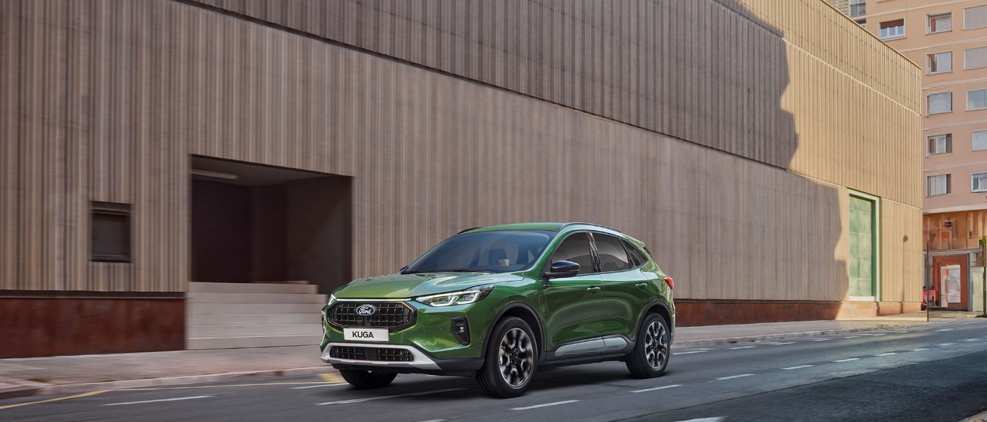 Ford Kuga in Grün. Dreiviertelansicht, fährt auf einer Straße.
