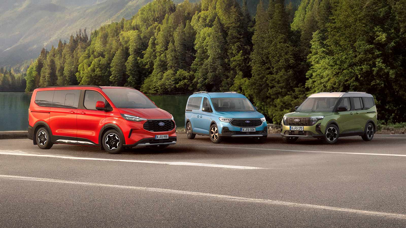 Ein roter Ford Tourneo Custom, ein blauer Tourneo Connect und ein grüner Tourneo Courier stehen nebeneinander auf einem Parkplatz, im Hintergrund ein grüner Wald.