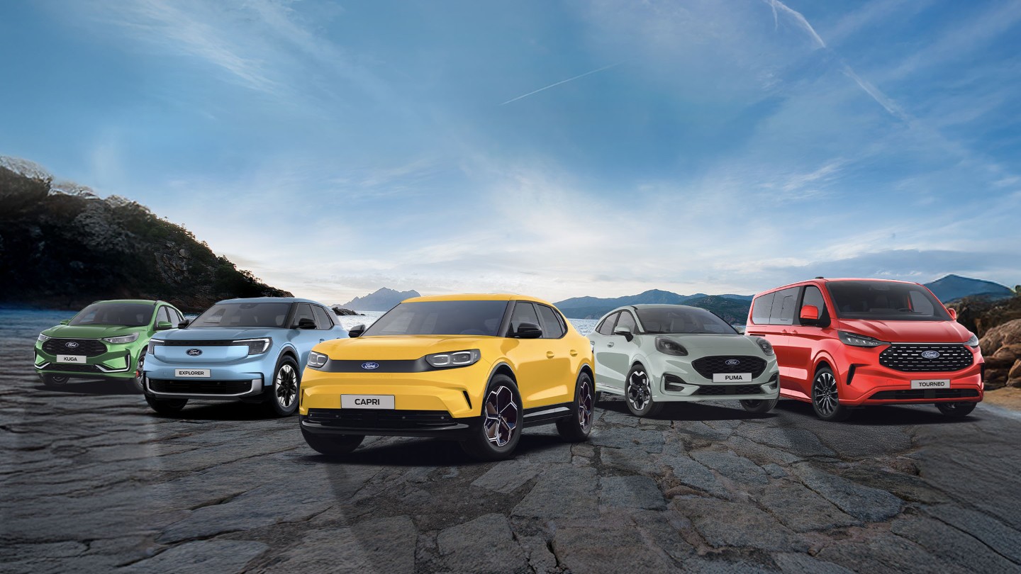 Ford Kuga in Grün, Explorer in Blau, Capri in Gelb, Puma in Grau und Tourneo Custom in Rot stehen vor einem See mit Bergen.