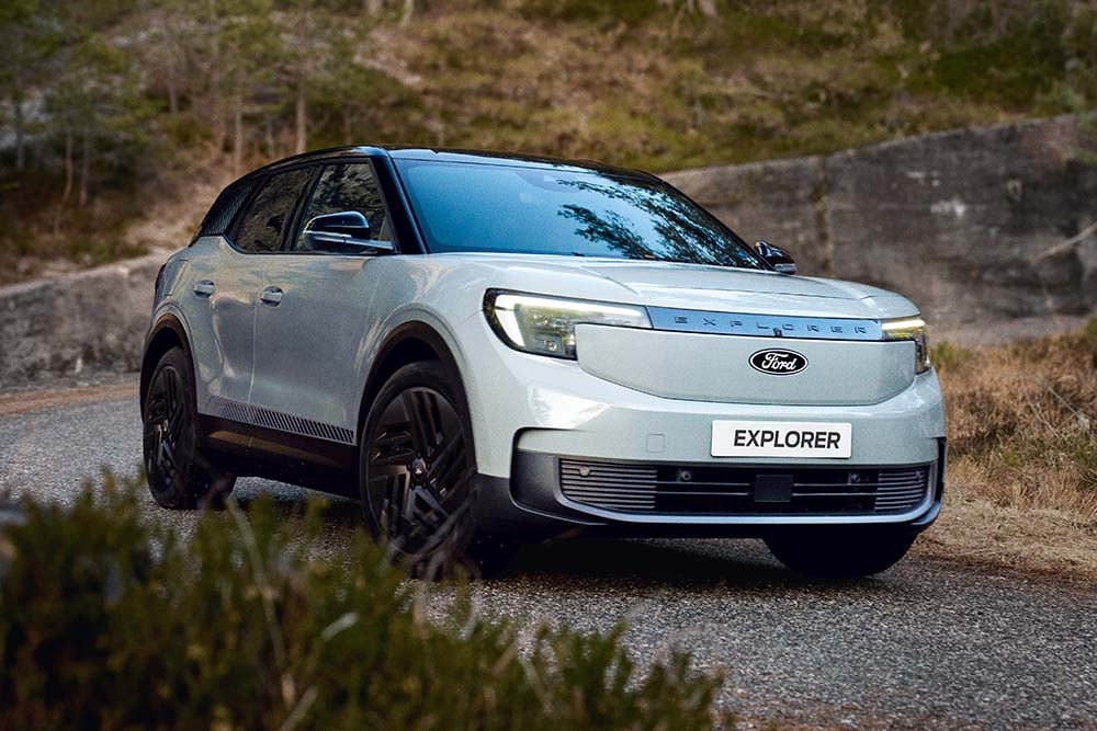 Ford Explorer in Blau. Dreiviertelansicht, fährt in der Kurve einer Bergstraße.