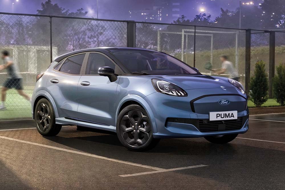 Ford Puma in Blau. Dreiviertelansicht, parkt bei Nacht vor einem Tennisplatz.