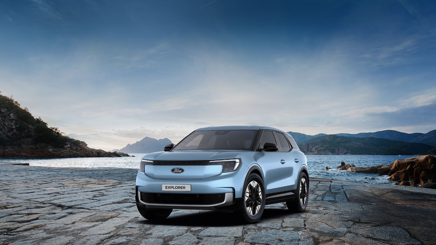 Ford Explorer in Blau. Dreiviertansicht, parkt vor einem See mit Berglandschaft.