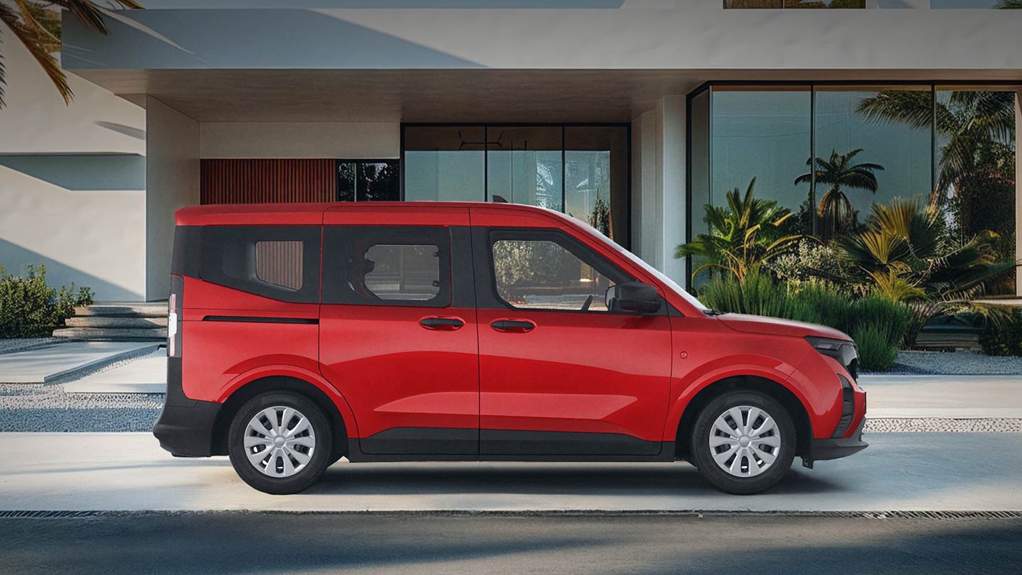 Ford Tourneo Courier in Rot. Seitenansicht, parkt vor dem Eingang eines Wohnhauses.