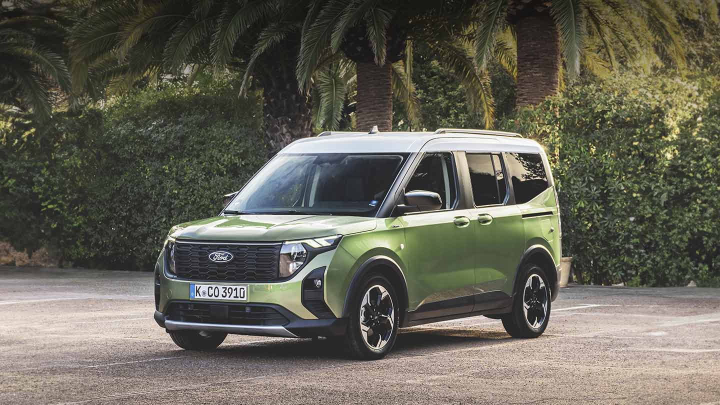 Ford Tourneo Courier in Grün. Dreiviertelansicht, parkt vor einer Palme.