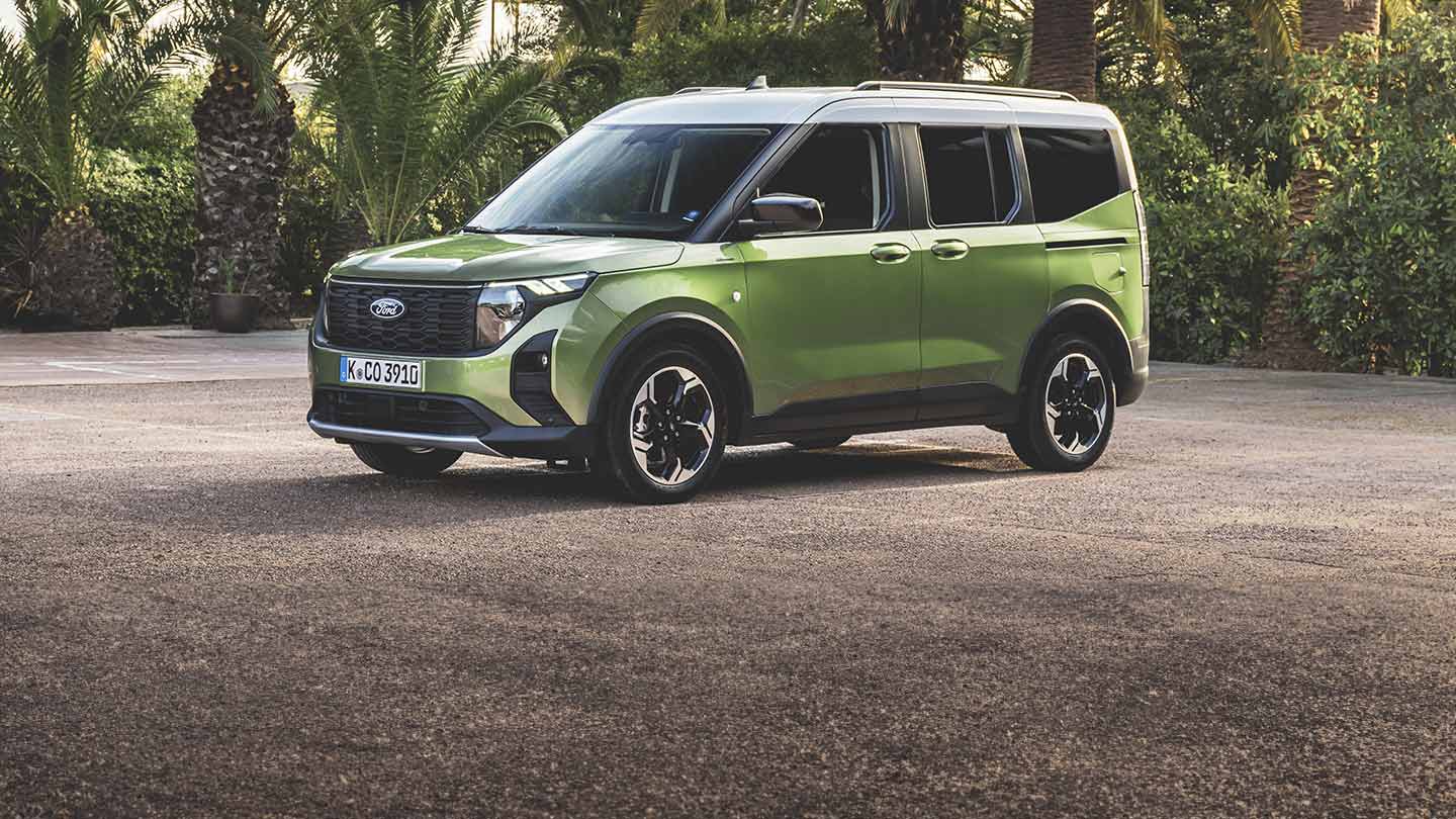 Ford Tourneo Courier in Grün. Dreiviertelansicht, parkt vor Palmen.