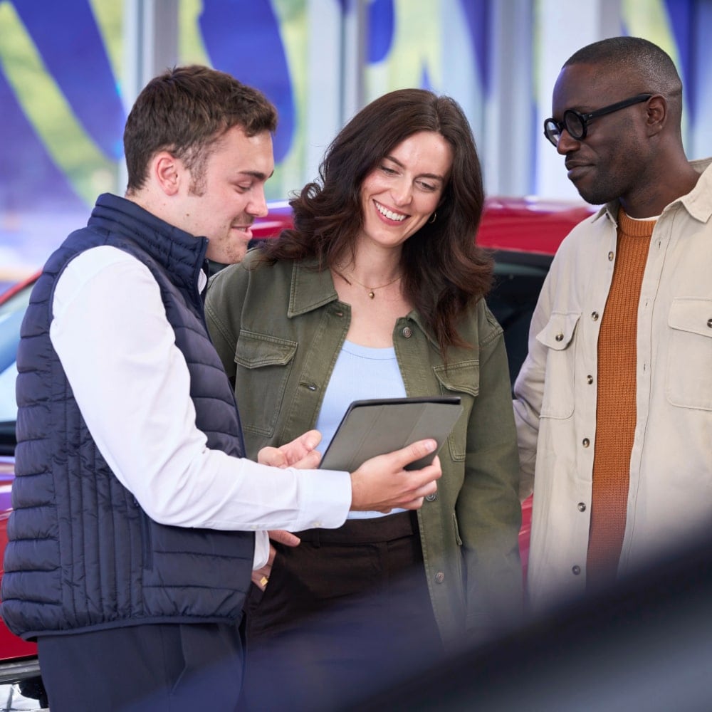 Ford Serviceberater erklärt seinen Kunden via Tablet das Angebot