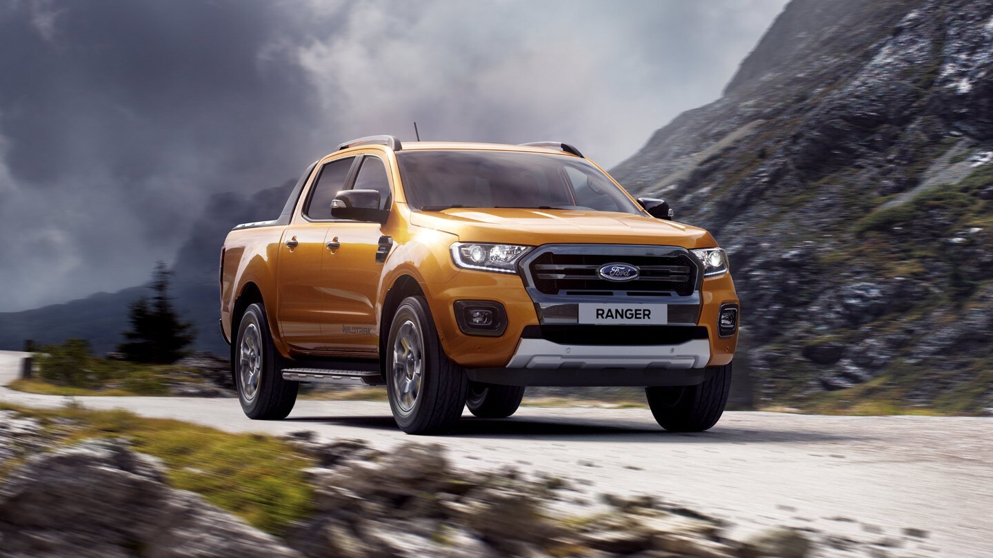 Ford Ranger Wildtrak in Orange. Dreiviertelansicht von vorne, fahrend auf einer Gebirgsstraße