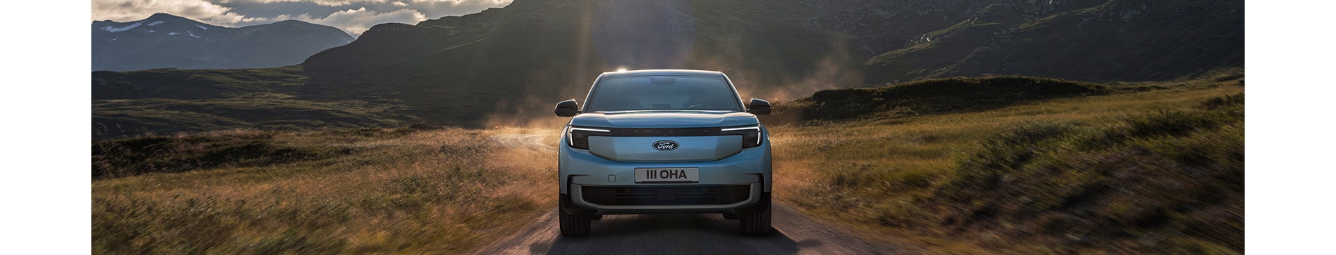 Ford Explorer in Blau. Frontansicht, fährt durch eine hügelige Landschaft.