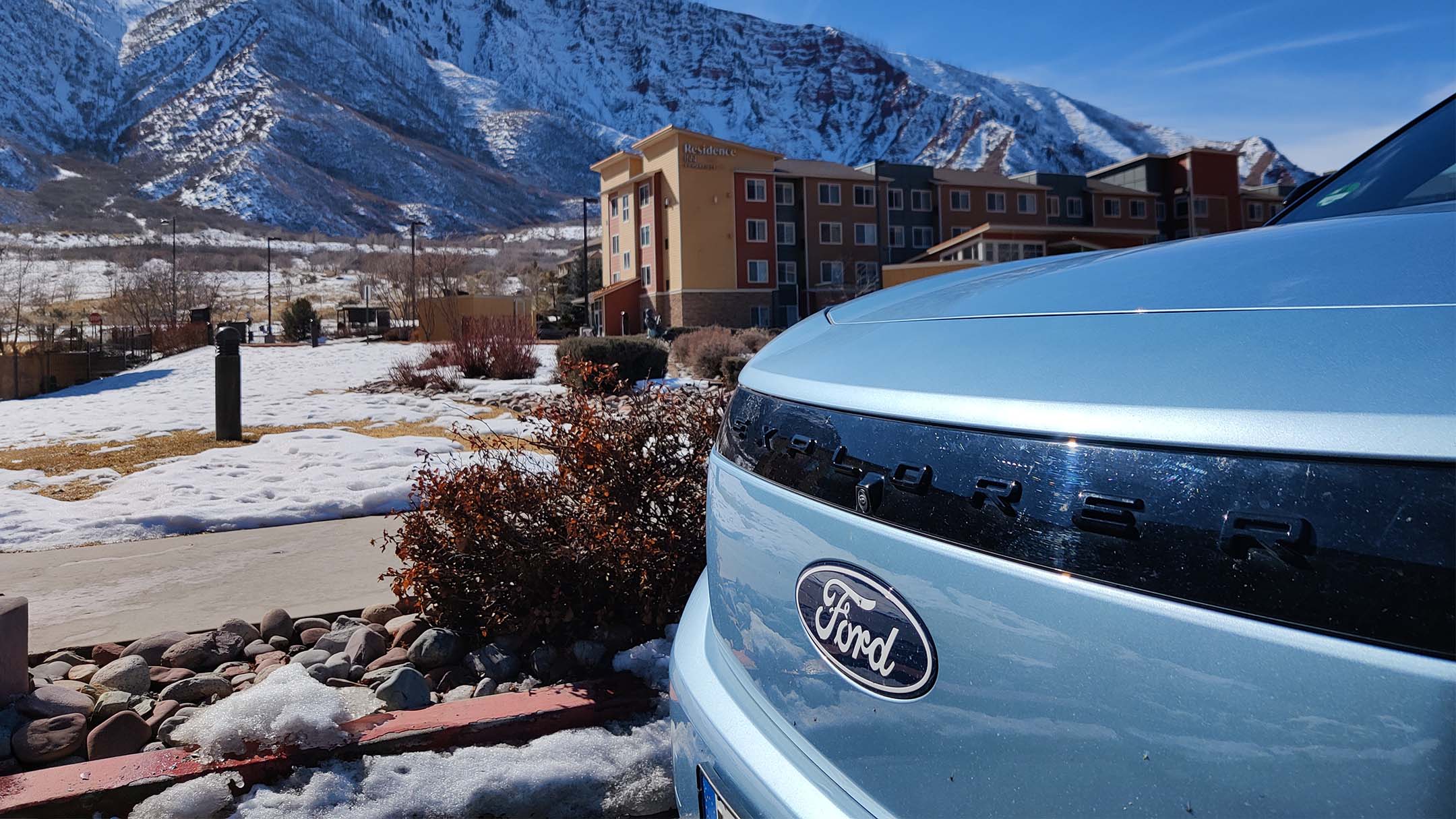 Vollelektrischer Ford Explorer in Blau. Detailansicht der Front und Ford-Logo.