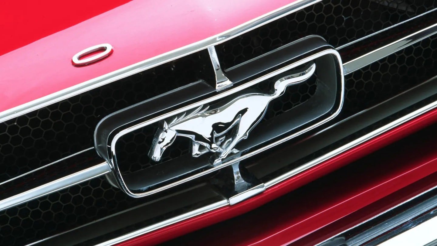 Nahaufnahme des Ford Mustang-Logos auf einem roten Ford Modell