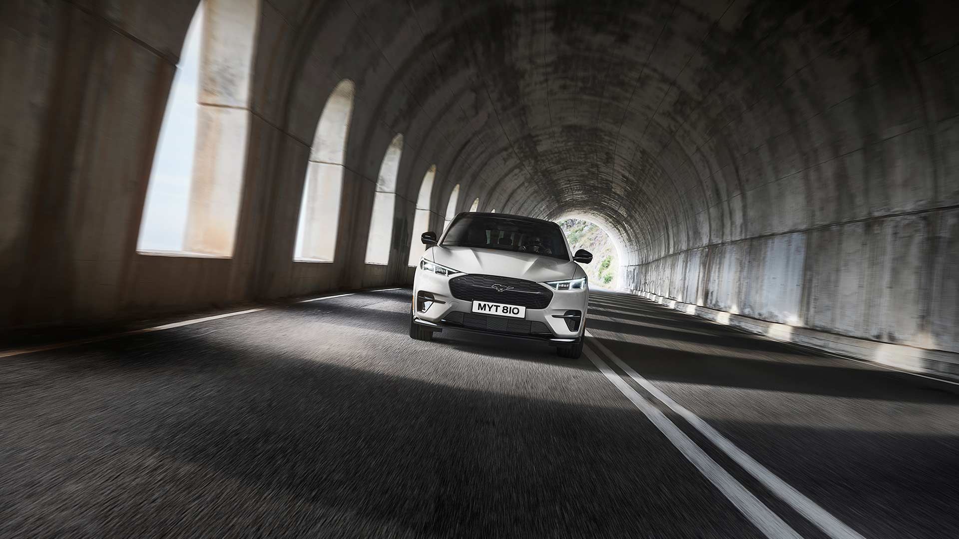 Ford Mustang Mach-E in Weiß. Frontansicht, fahrend durch einen Tunnel.