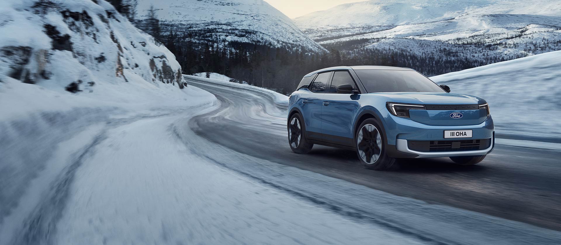 Ford Explorer in Blau. Dreiviertelansicht, fahrend auf einer verschneiten Straße. 