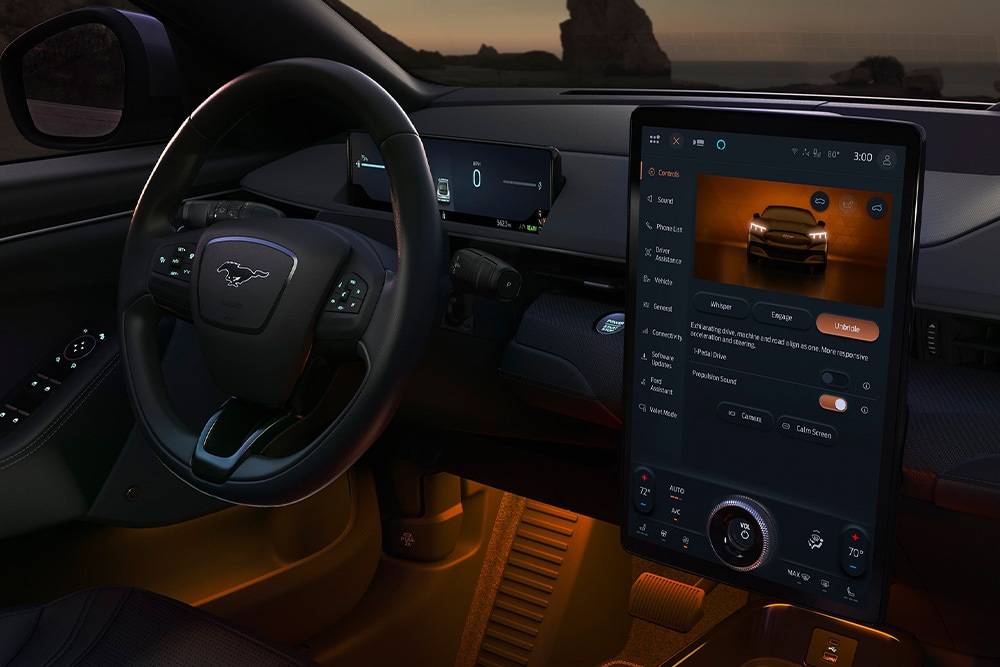 Innenraumaufnahme eines Ford Elektroautos. Detailansicht Armaturenbrett und Lenkrad mit Pony-Logo.