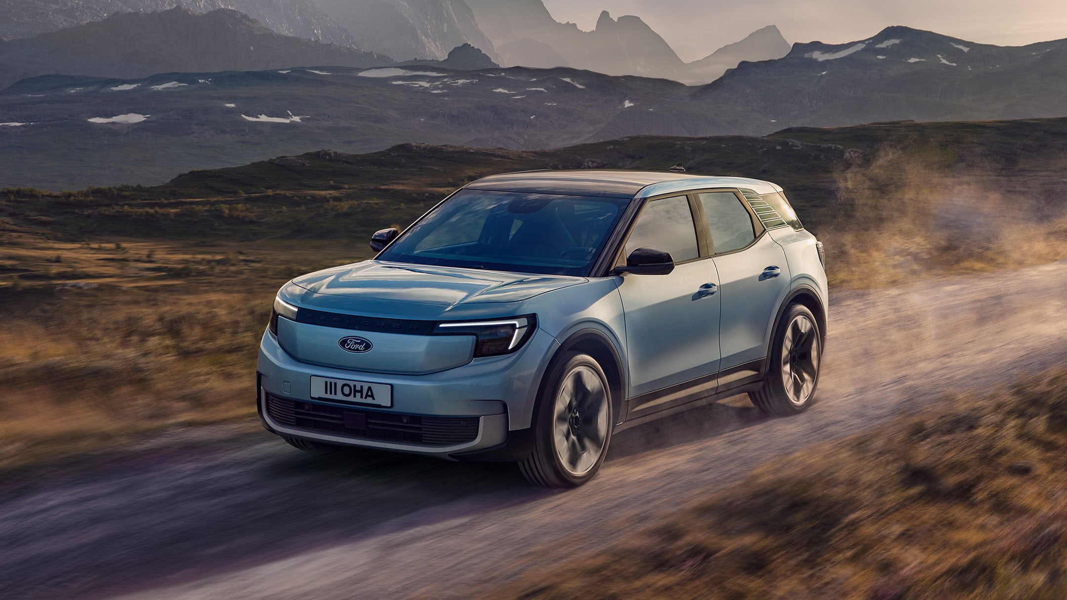 Der vollelektrische Ford Explorer in Blau. Frontansicht, fahrend auf einer Bergstraße.