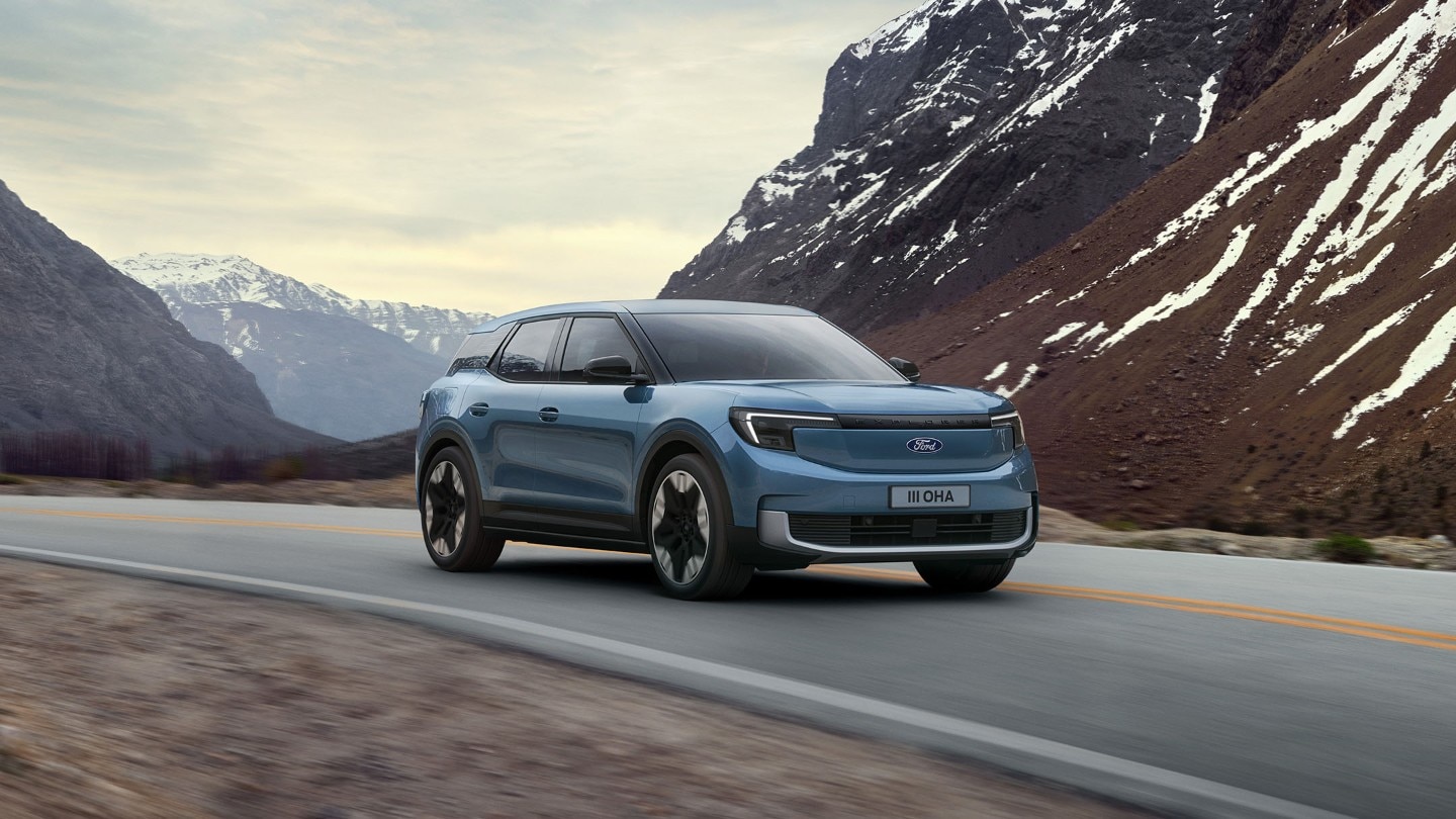 Der vollelektrische Ford Explorer in Blau. Frontansicht, fahrend auf einer Bergstraße.