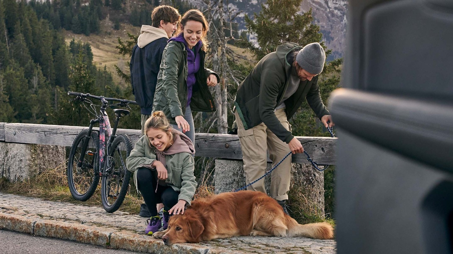 Eine vierköpfige Familie mit Hund, die Spaß auf einer Reise hat