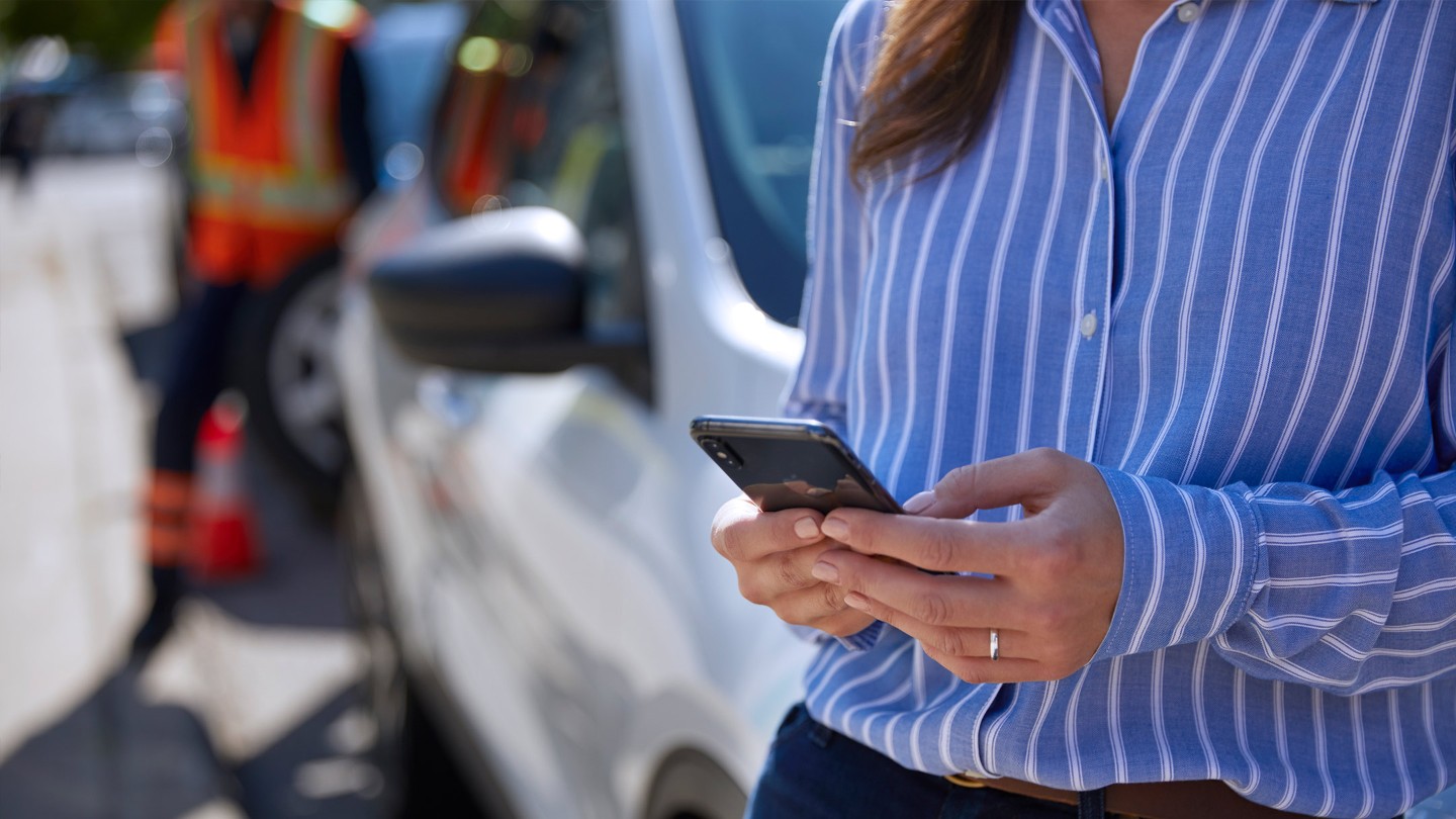 Frau hält ein Mobiltelefon in der Hand