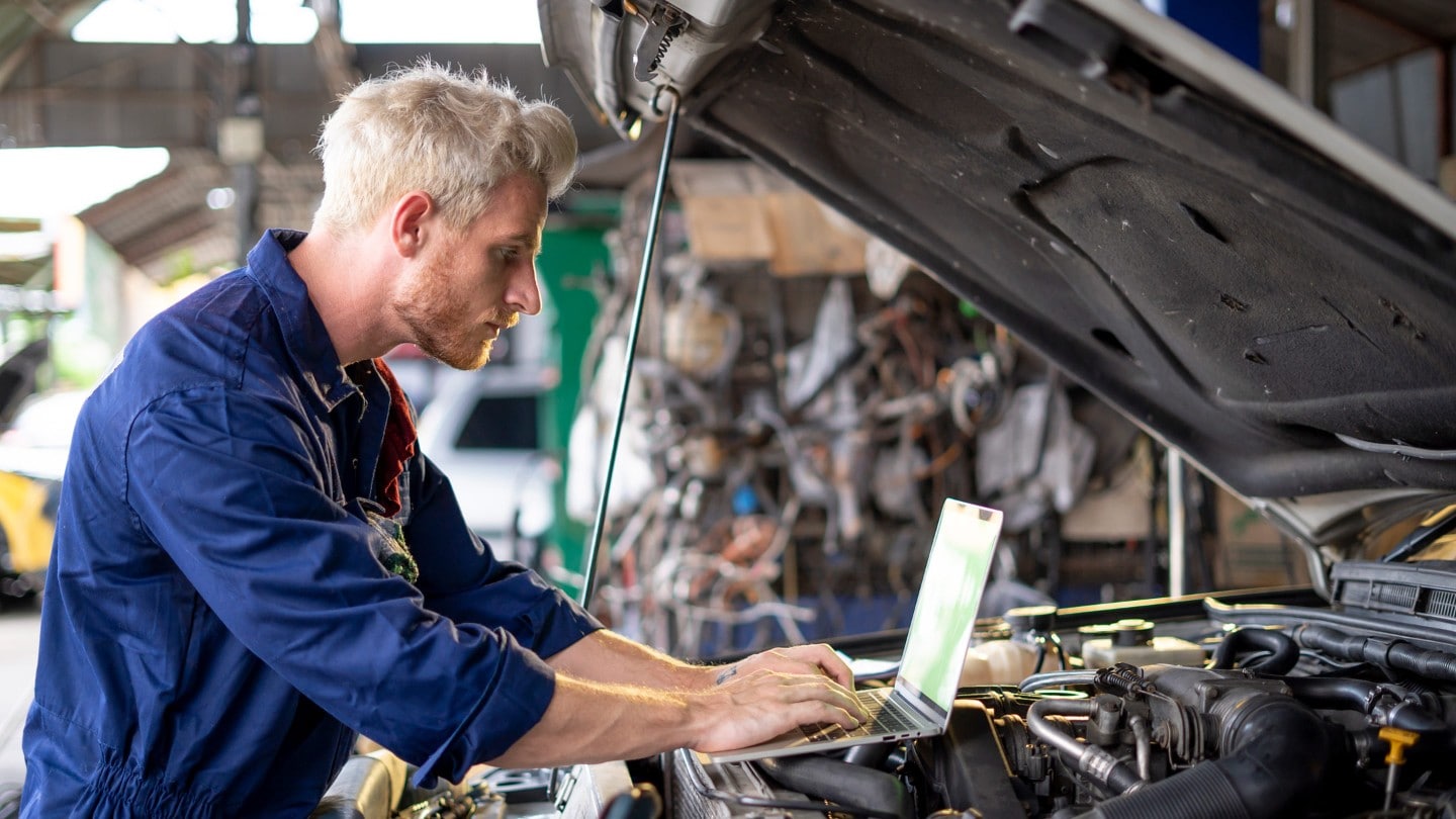 Mechaniker der ein Fahrzeug inspiziert