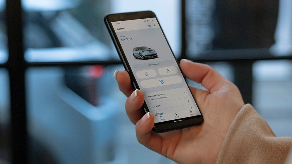 Eine Person hält ein Smartphone mit geöffneter FordPass App in der Hand.