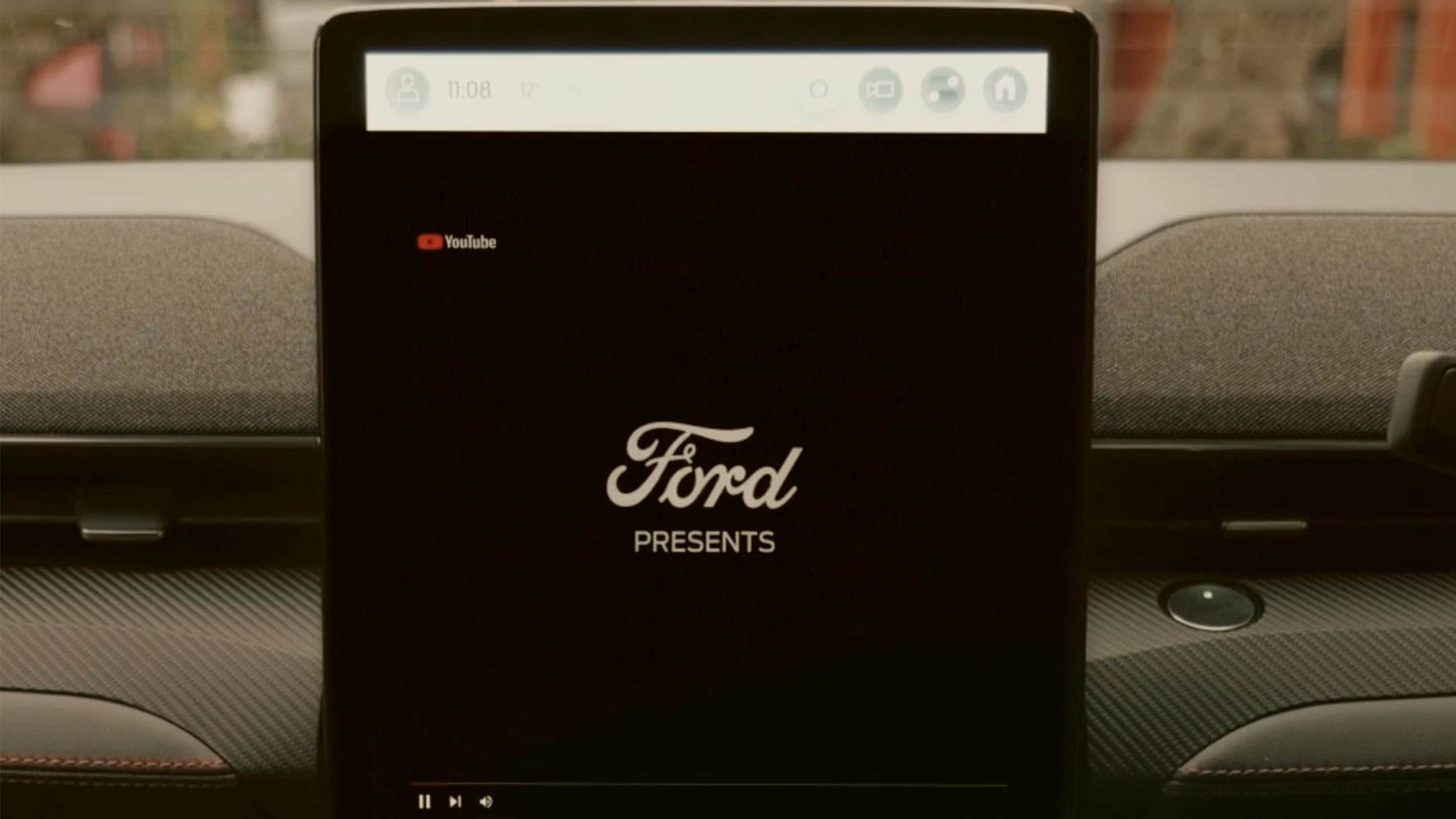 Ein Ford Touchscreen in einem Fahrzeug zeigt das Ford Logo auf schwarzem Hintergrund.