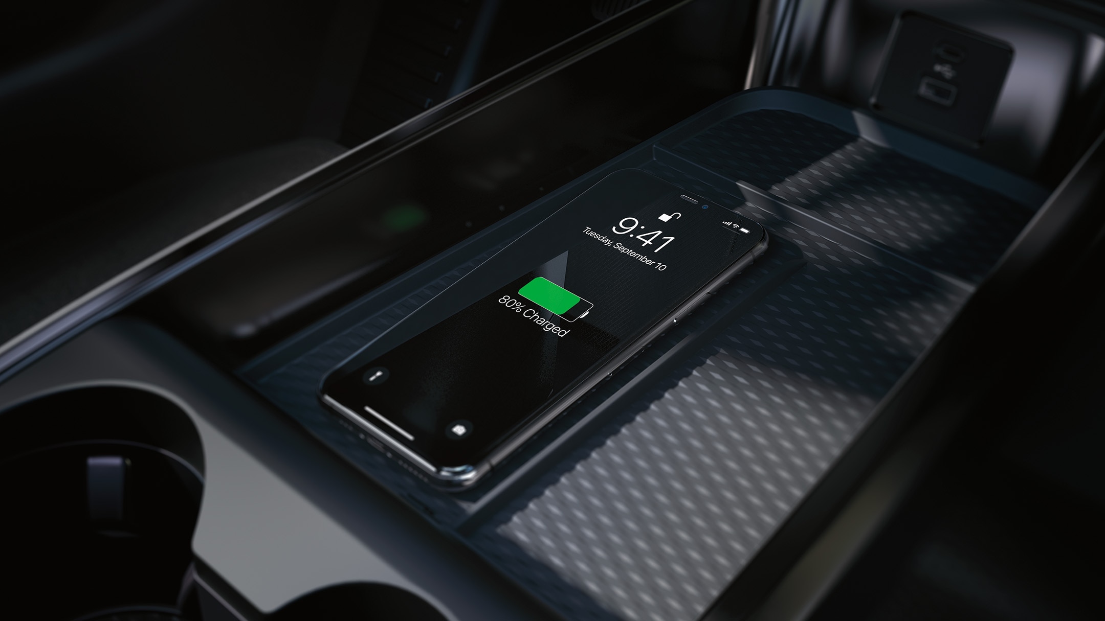 Nahaufnahme der induktiven Ladestation in der Mittelkonsole, auf dem ein Smartphone aufgeladen wird.