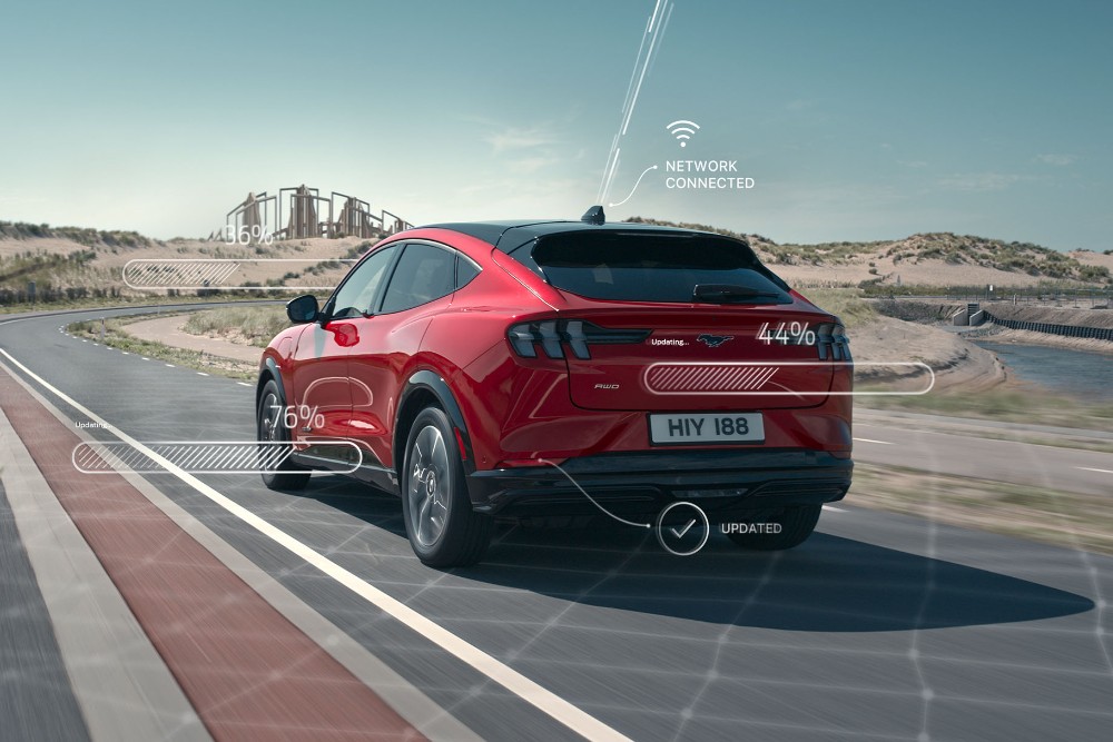 Ford Mach-E in Rot. Heckansicht, auf einer Straße fahrend