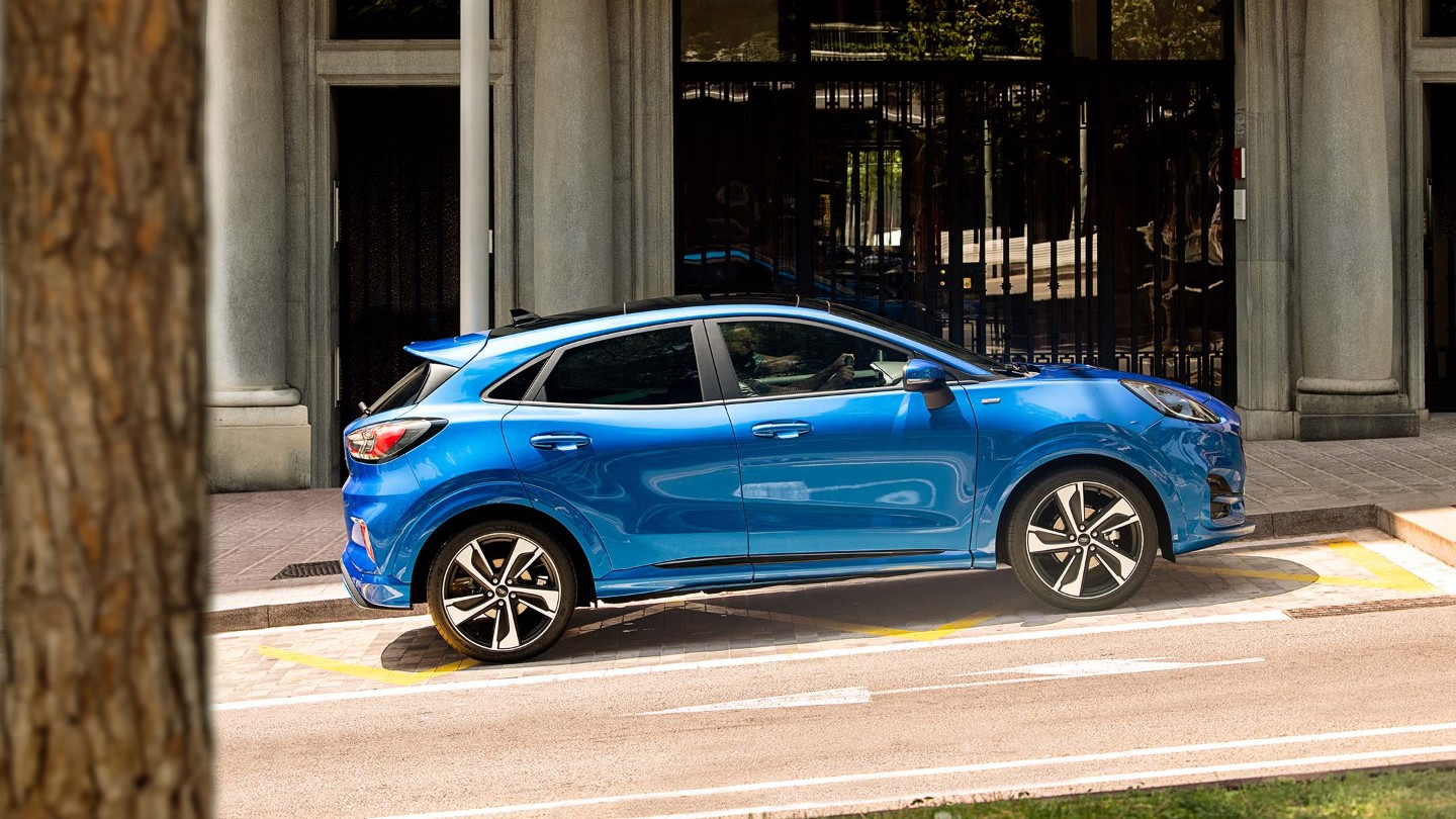 Ford Puma in Blau. Seitenansicht, auf einer Straße parkend.