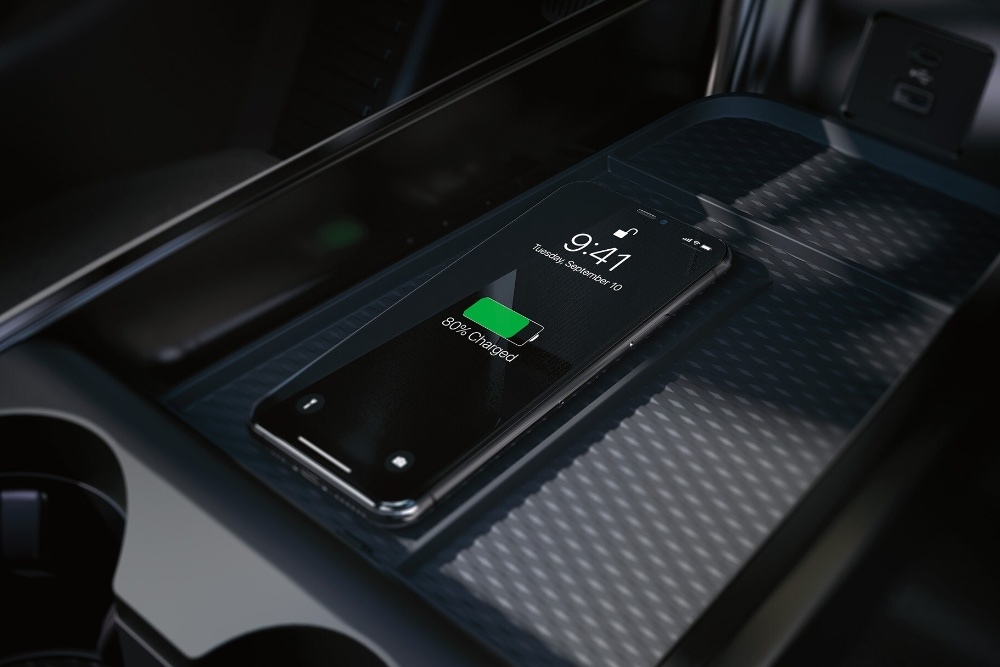 Nahaufnahme der induktiven Ladestation in der Mittelkonsole, auf dem ein Smartphone aufgeladen wird.