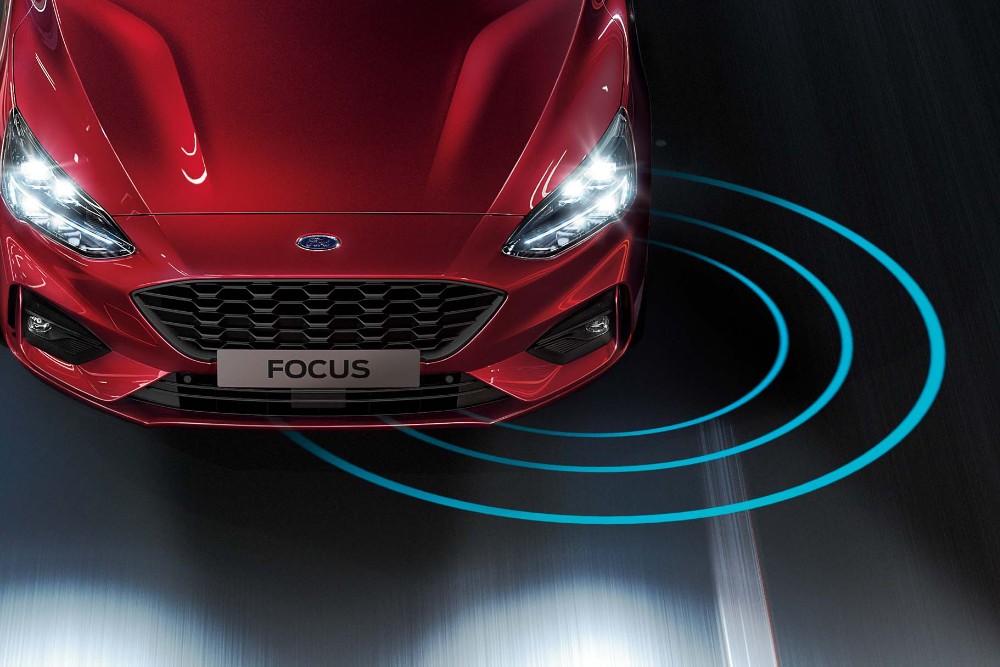 Ford Focus in Rot. Ansicht von oben auf einer Straße fahrend.