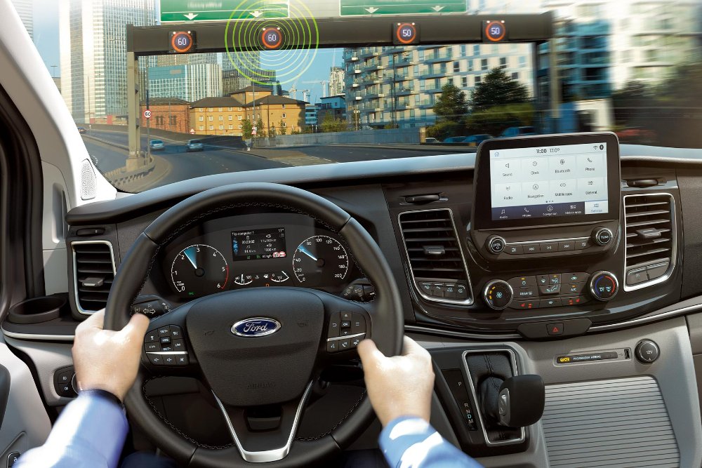 Fahrzeuginnenraum mit Fokus auf das Lenkrad, Visualisierung Verkehrsschild-Erkennungssystem