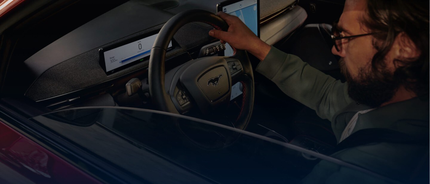Ford Mustang Mach-E Innenraum. Blick durch geöffnetes Fenster, Mann sitzt auf dem Fahrersitz
