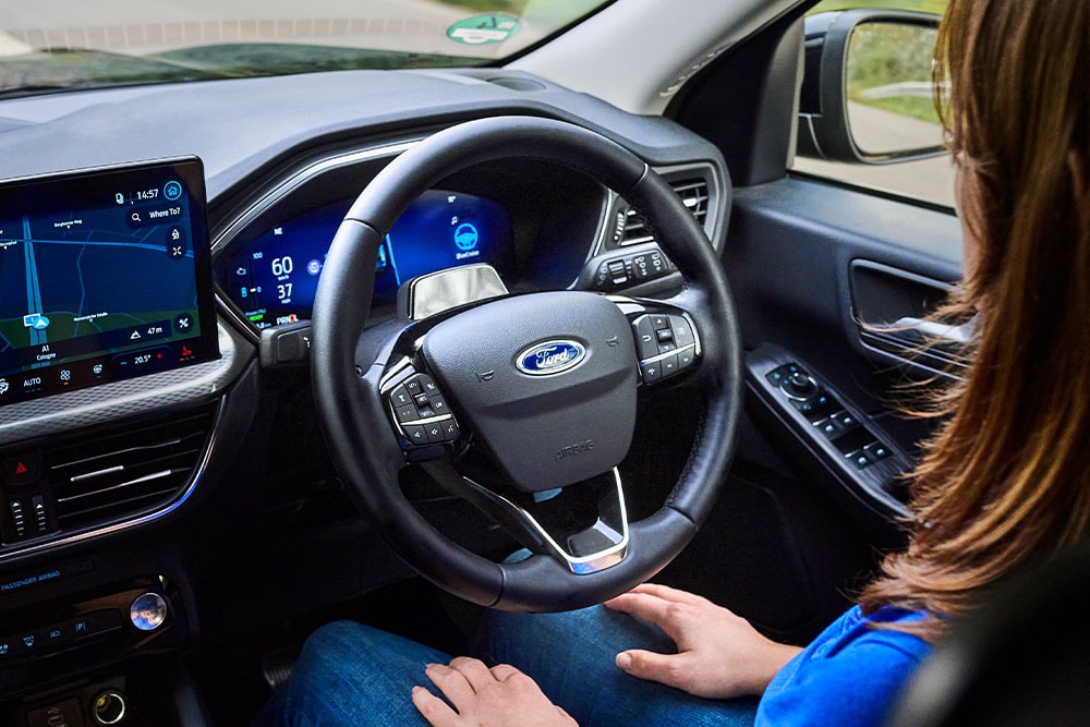 Innenraum eines Ford Fahrzeugs. Ansicht der Instrumententafel und Lenkrad. Anzeige der BlueCruise-Funktion.