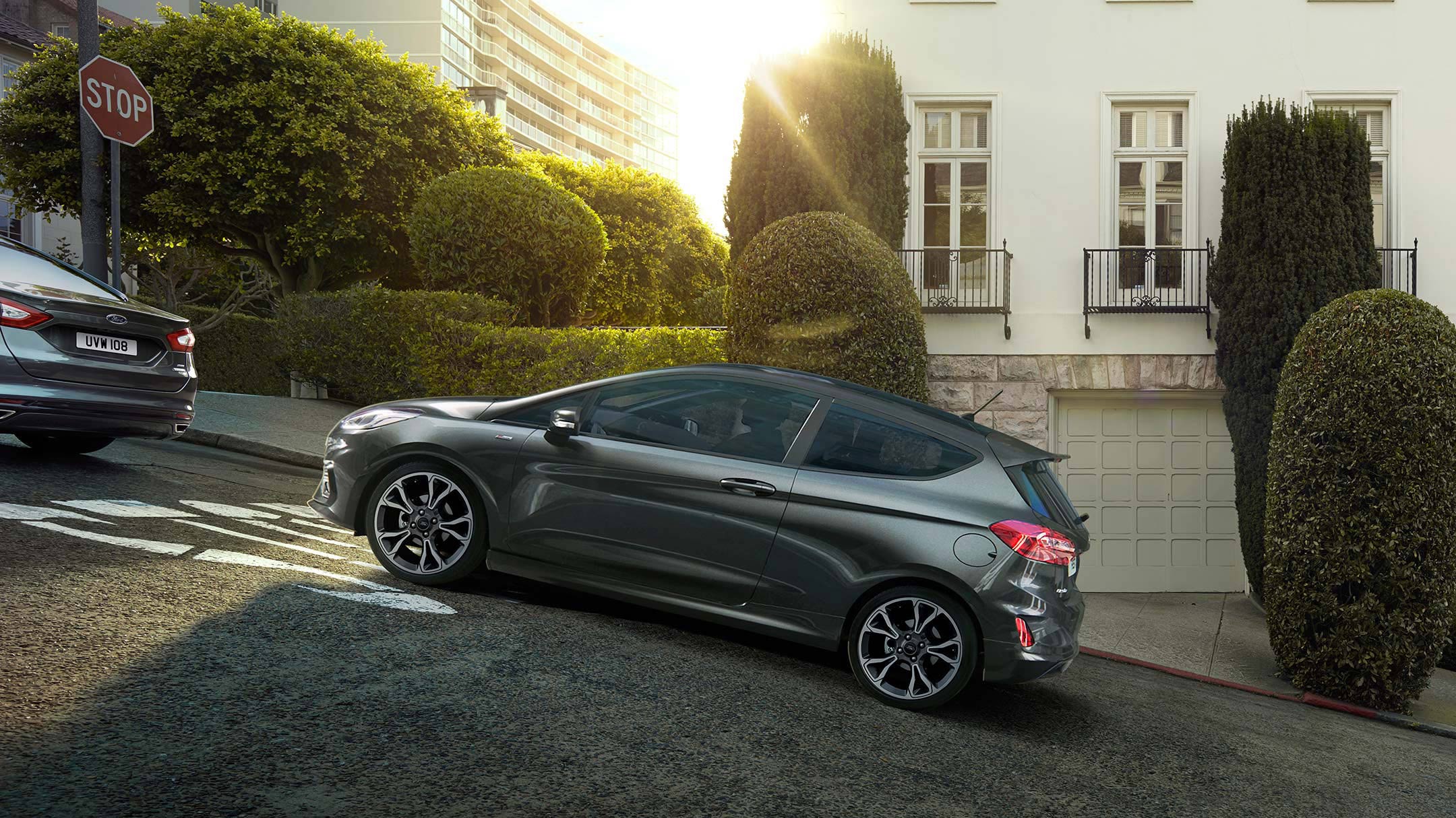 Ford Fiesta in Grau. Seitenansicht, bergauffahrend