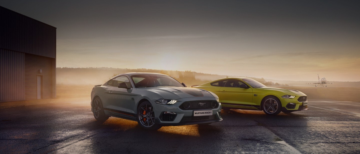 Ford Mustang in Weiß und Gelb. Dreiviertelansicht, bei Abenddämmerung