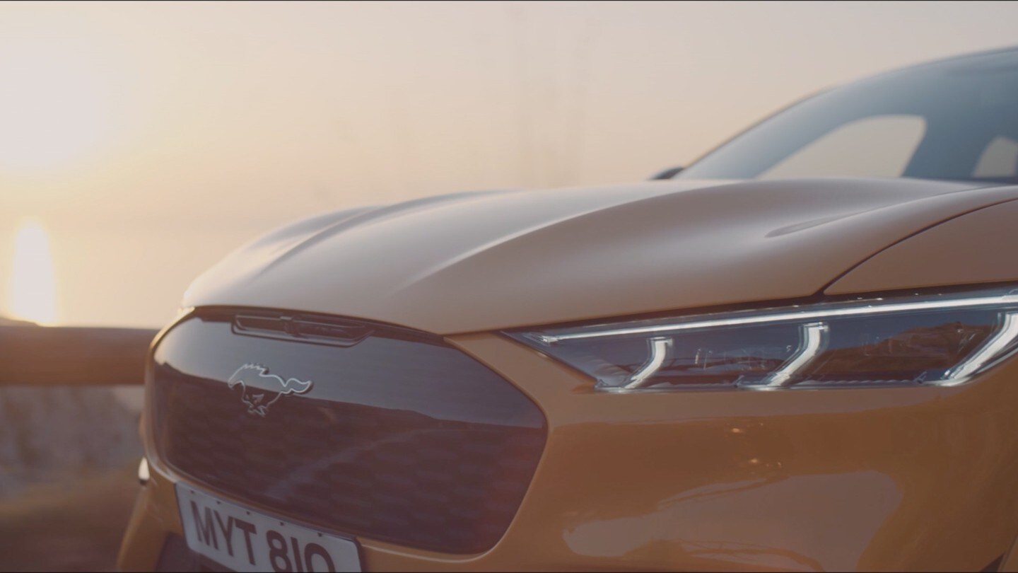Mustang Mach-E in Orange. Detailansicht Pony-Logo