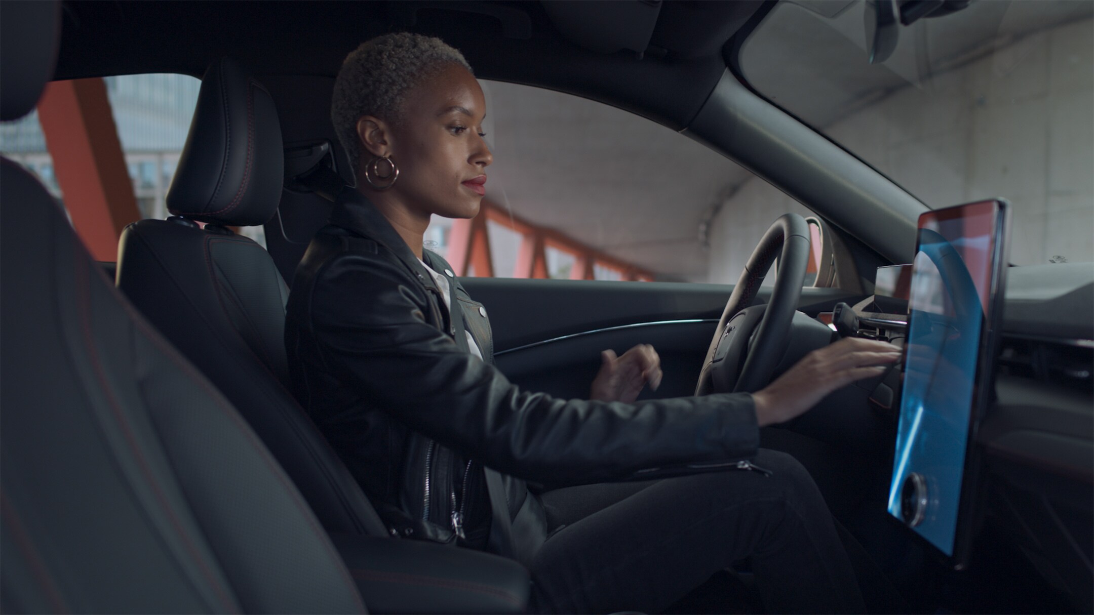 Ford Mustang Mach-E Innenraum. Frau bedient den Ford SYNC 4A Touchscreen