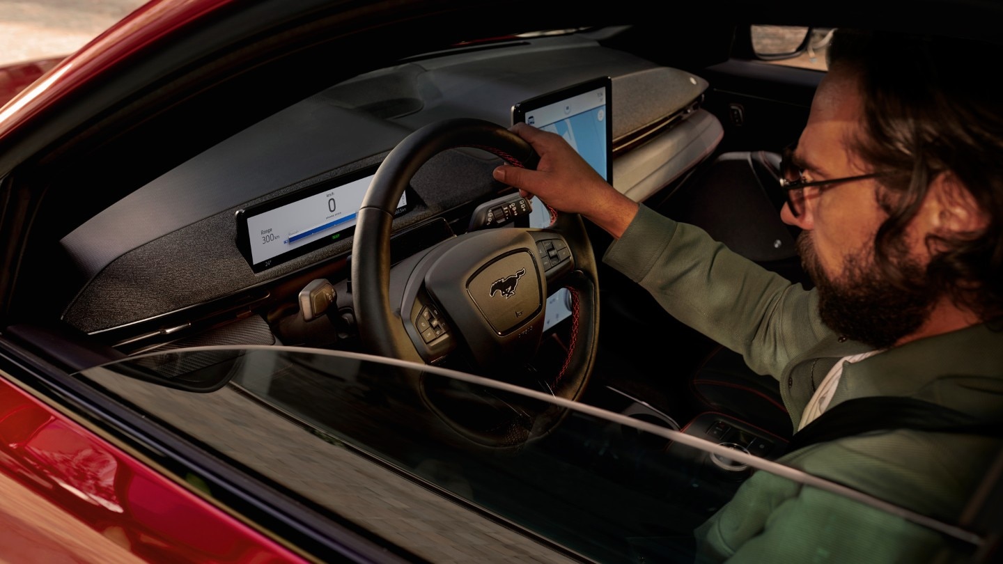 Ford Mustang Mach-E Innenraum. Blick durch das Seitenfenster auf den Fahrer am Steuer