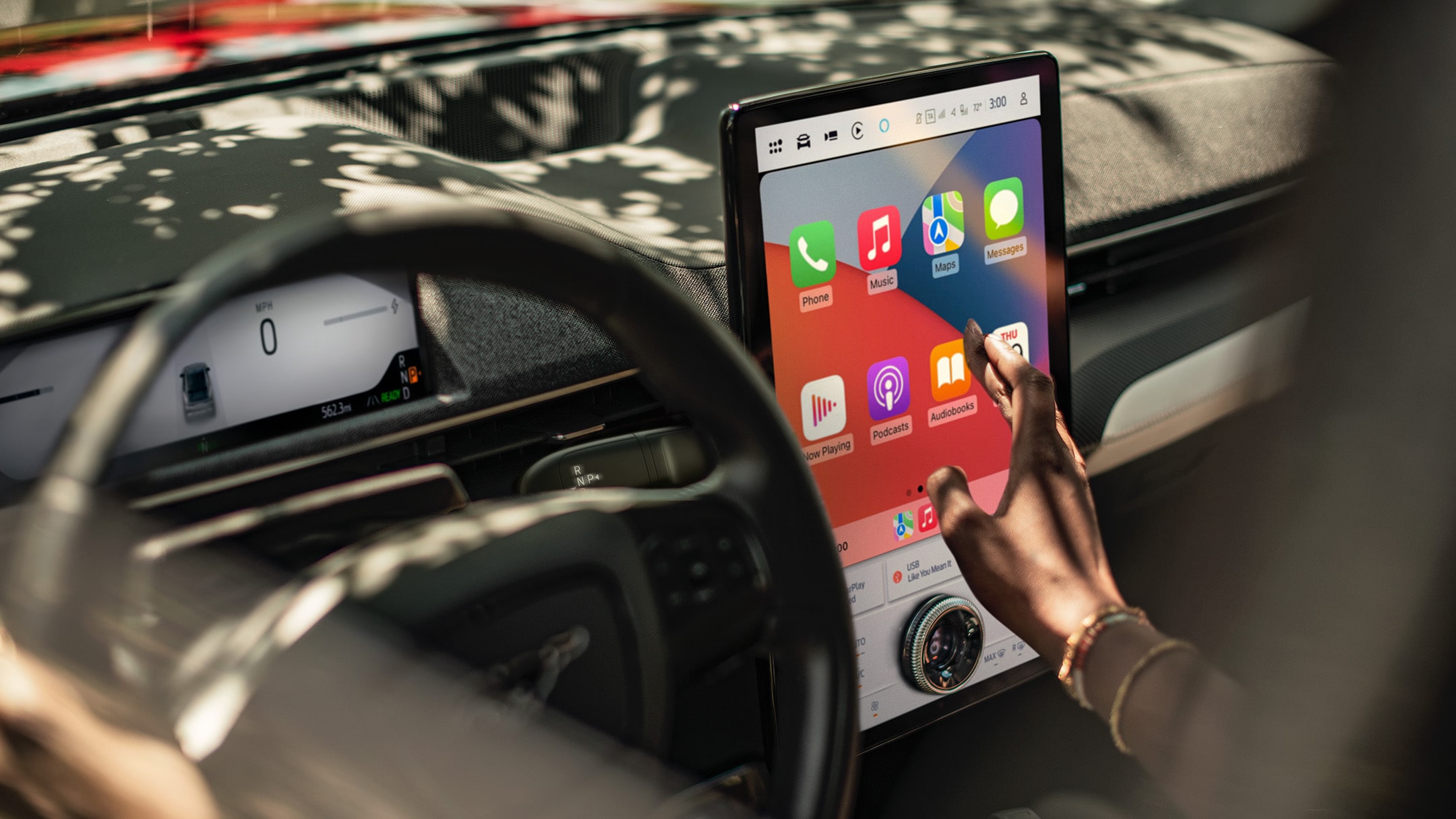 Ford Mustang Mach-E. Innenraumansicht, eine Frau betrachtet den Ford SYNC 4A Touchscreen.
