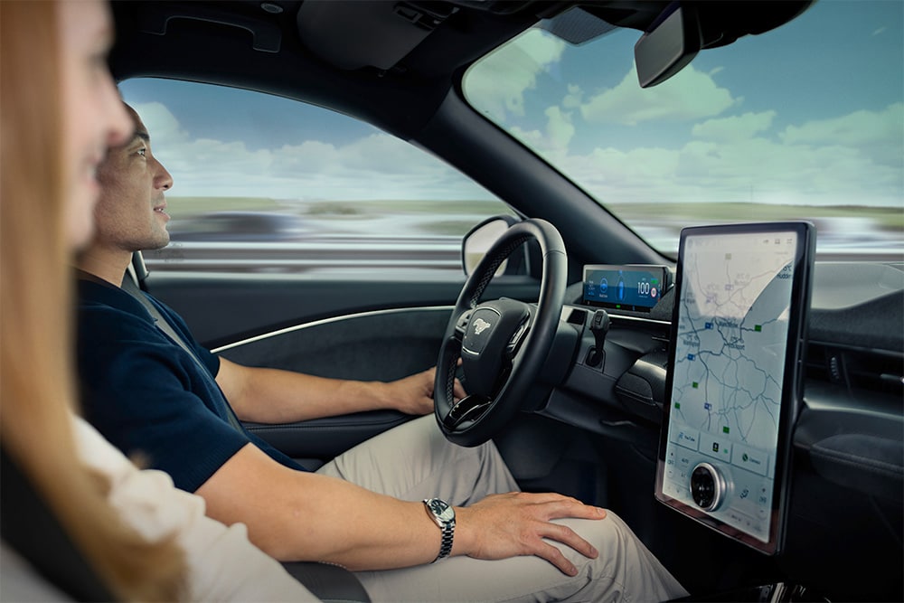 Nahaufnahme eines Fahrers und Beifahrers im vorderen Bereich eines Mustang Mach-E.