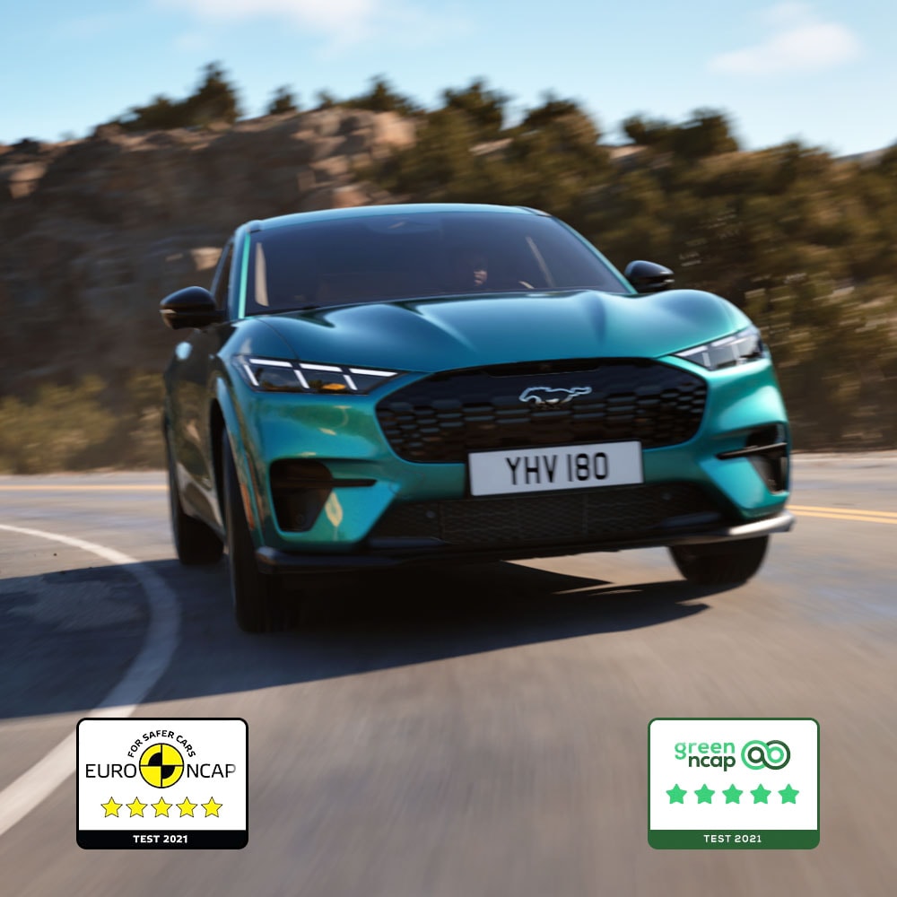 Ford Mustang Mach-E in Blau. Frontansicht, fahrend auf einer Bergstraße.