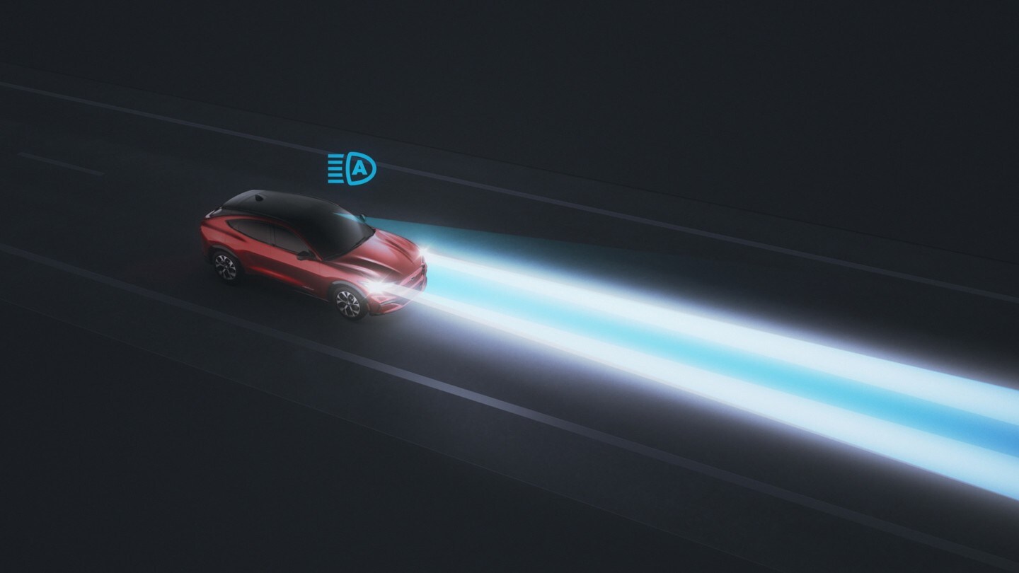 Ford Mustang Mach-E in Rot. Dreiviertelansicht von vorne, fahrend bei Nacht mit Fernlicht