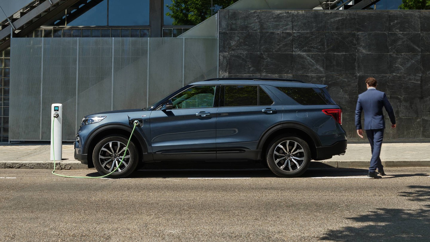 Ford Explorer Plug-in-Hybrid in Blau. Seitenansicht, Ladevorgang an einer Ladestation