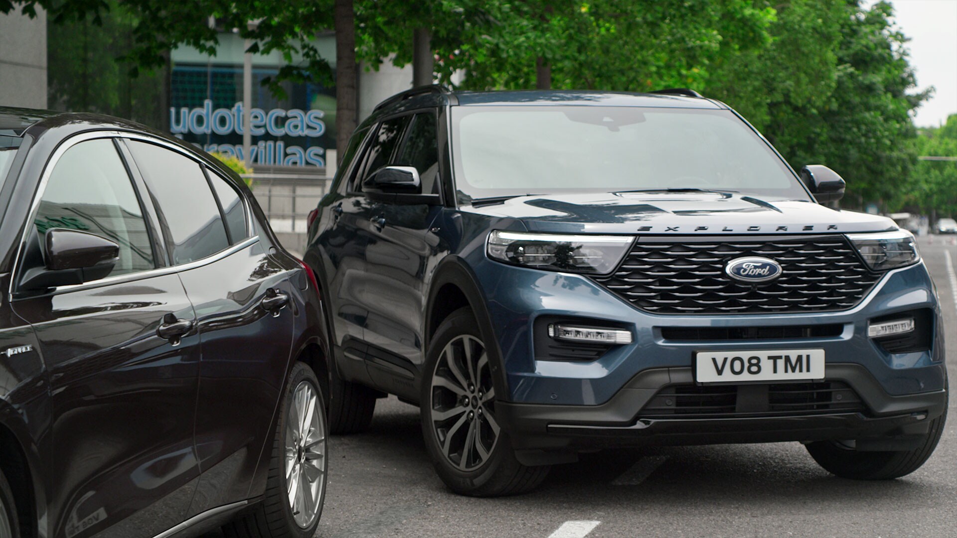 Ford Explorer Plug-in-Hybrid in Blau. Dreiviertelansicht, parkt aus einem Parkplatz aus