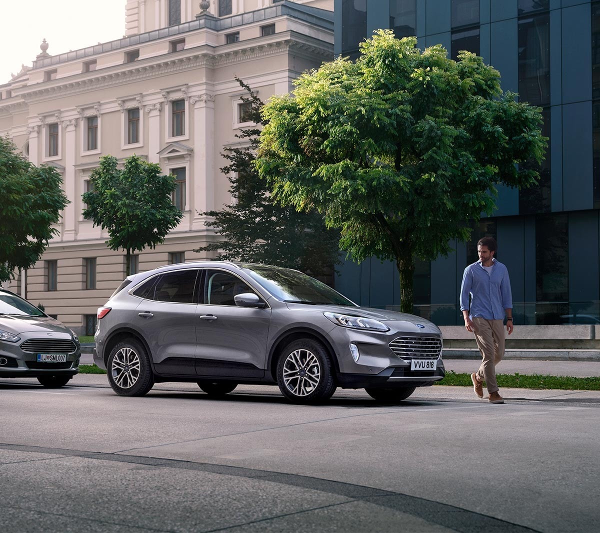 Ford Kuga in Silber. Dreiviertelansicht, parkend vor einem Altbau