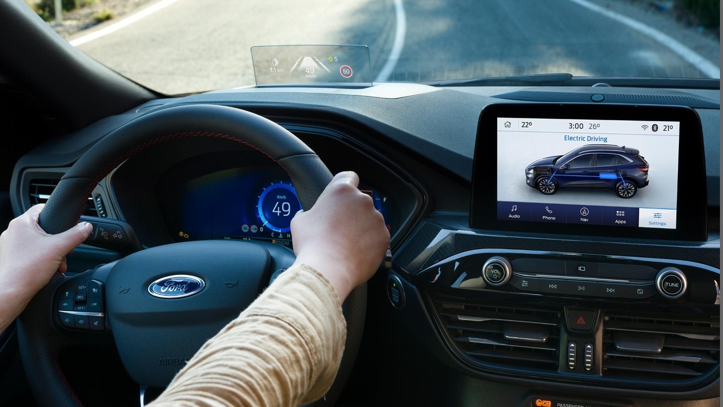 Ford Kuga Innenraum. Detailansicht des Lenkrads und der Mittelkonsole mit Touchscreen. Hände des Fahrers am Lenkrad