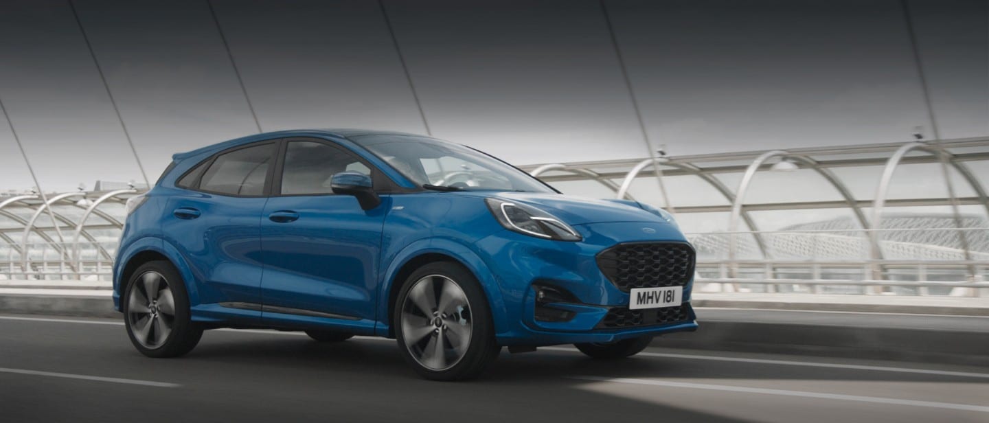 Blauer Ford Puma fährt über Brücke