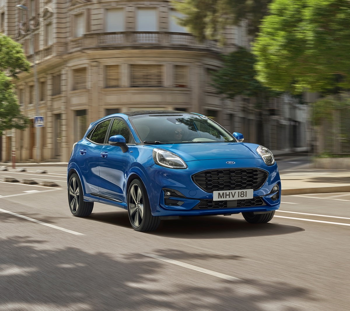 Ford Puma in Blau. Dreiviertelansicht, fahrend in Stadt über Kreuzung