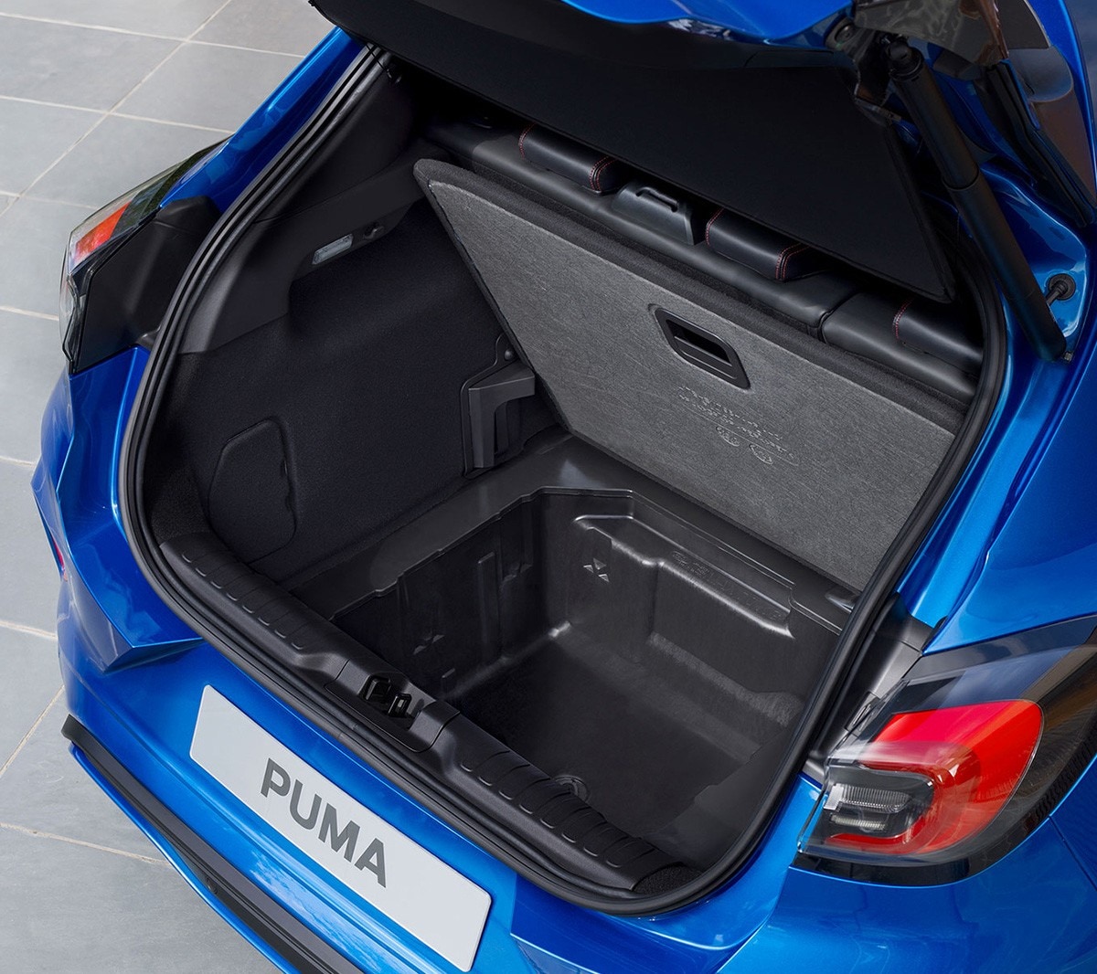 Ford Puma in Blau. Heckansicht, Blick auf geöffneten Gepäckraum und Ford MegaBox