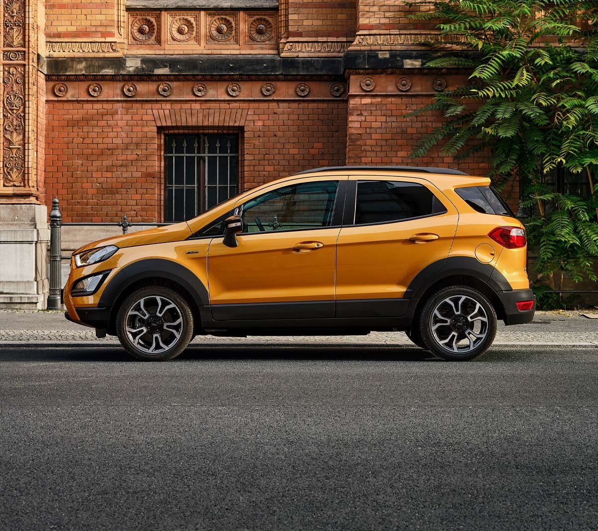 Ford EcoSport Active in Orange. Seitenansicht, parkend vor einem Gebäude in der Stadt